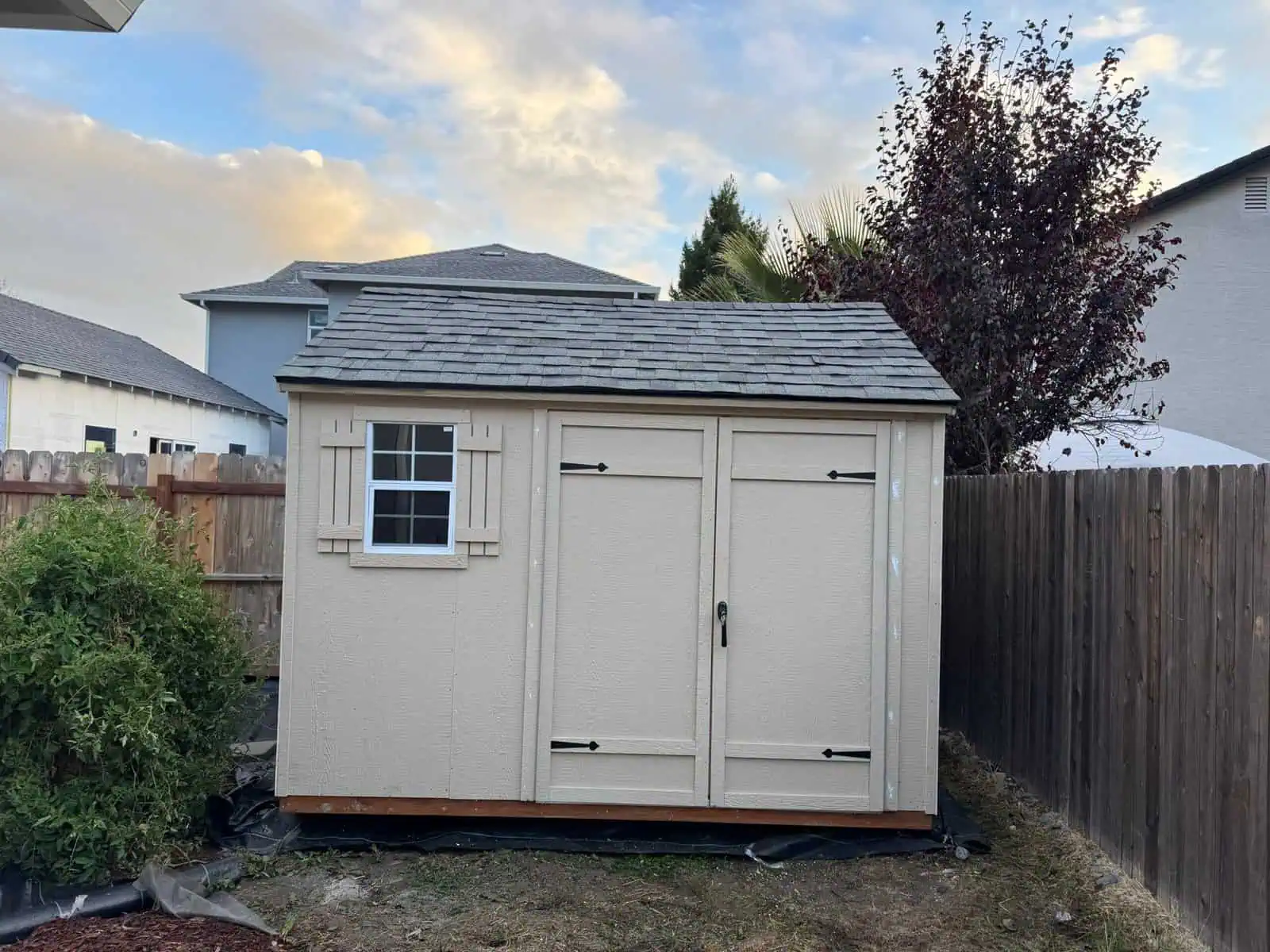 Durable outdoor storage shed with double doors and window for garden tools and equipment.