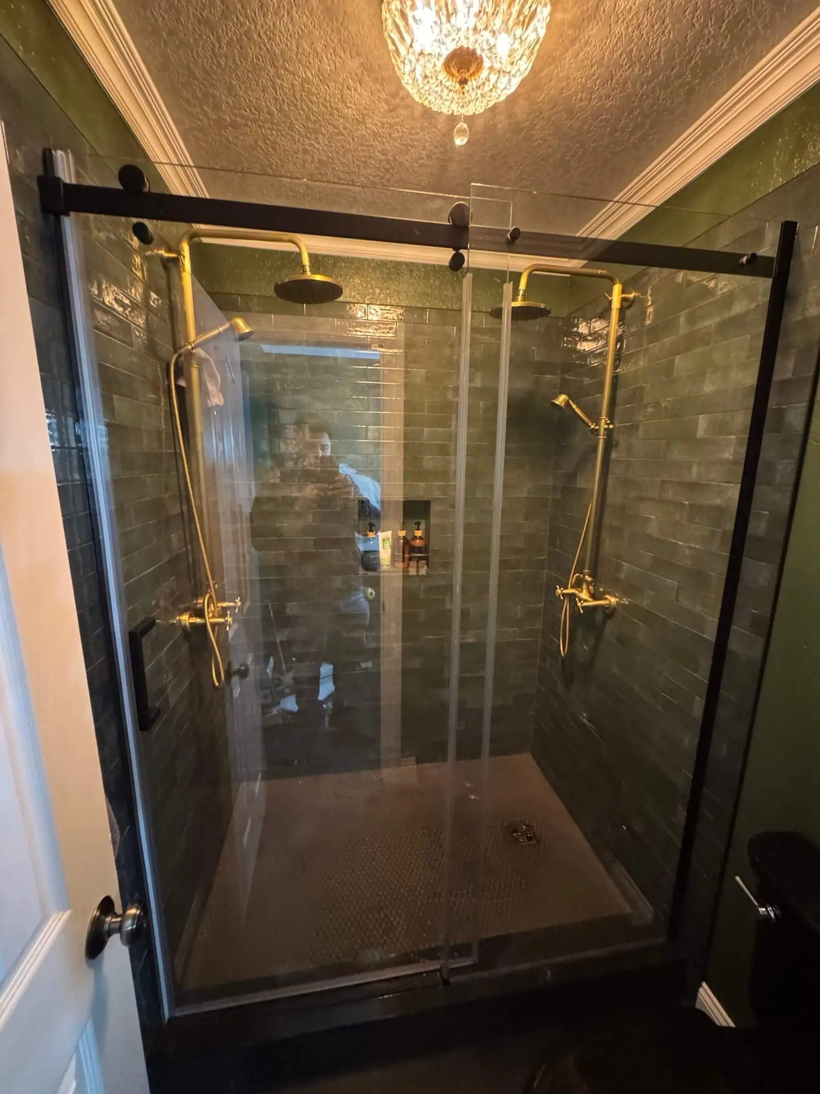 Shower with gold fixtures and glass enclosure in a contemporary bathroom setting.