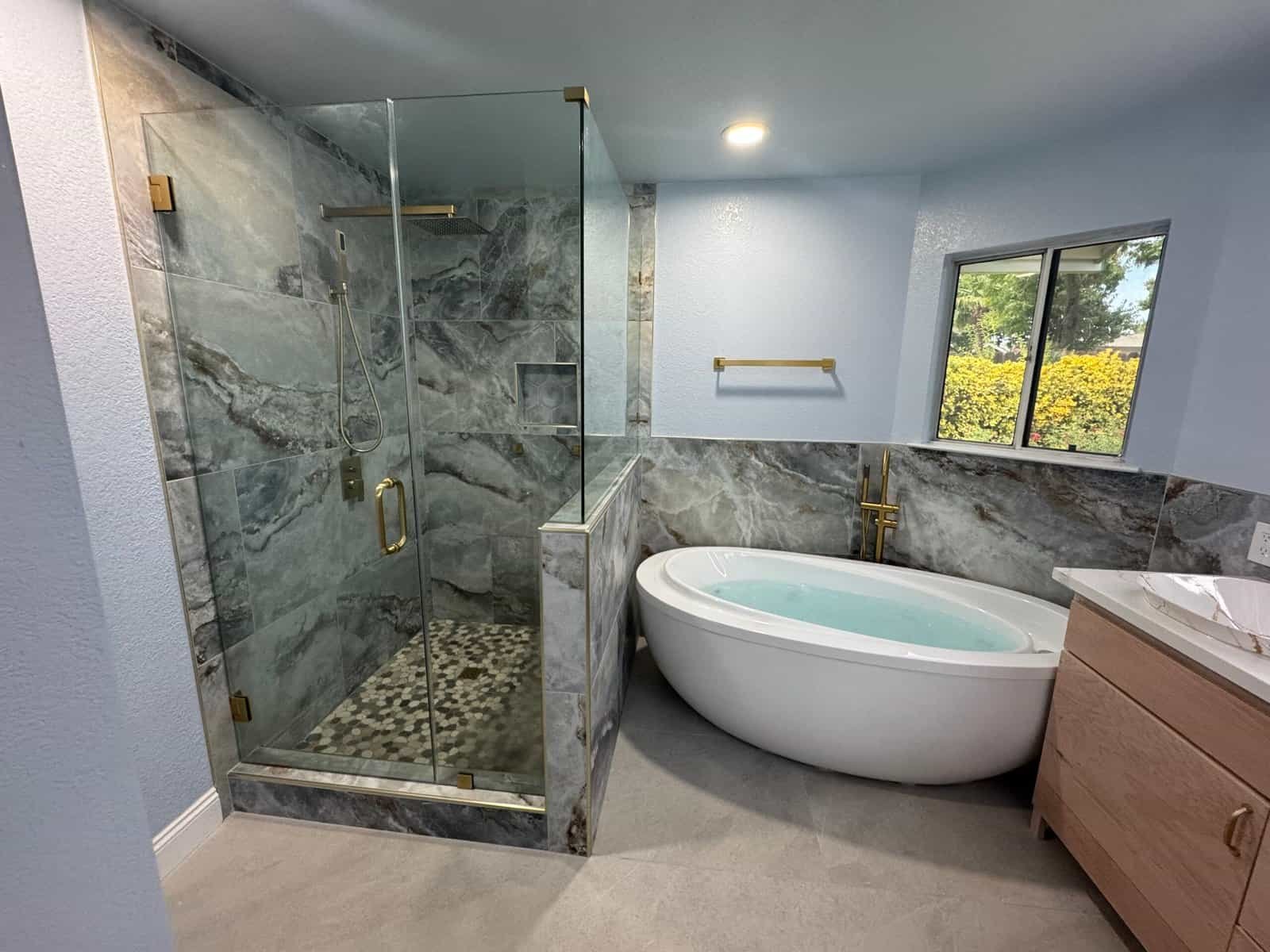 Bathroom with glass shower enclosure and luxurious soaking tub.