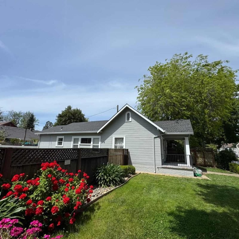 Beautiful suburban house with lush green lawn and vibrant flower beds.