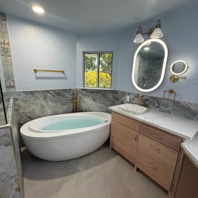 Bathroom with bathtub, vanity, and illuminated mirror in a contemporary home.